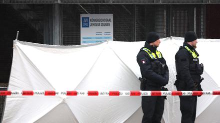 Zwei Polizeibeamte stehen vor dem Versammlungsgebäude der Zeugen Jehovas im Stadtteil Alsterdorf.