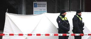 Zwei Polizeibeamte stehen vor dem Versammlungsgebäude der Zeugen Jehovas im Stadtteil Alsterdorf.