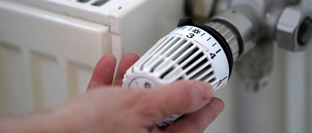 ARCHIV - 09.03.2022, Hamburg: ILLUSTRATION - Eine Frau dreht an einem Heizungsthermostat. Die Heizung zu Hause soll künftig zum Großteil mit erneuerbarer Energie laufen - das hat die Bundesregierung schon kurz nach der Wahl verabredet. Nun werden mehr Einzelheiten bekannt. Die sind aber noch hochumstritten. (zu dpa "Heizen mit mehr Wind und Sonne") Foto: Marcus Brandt/dpa +++ dpa-Bildfunk +++