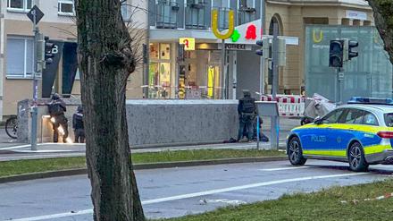 Polizisten in Spezialausrüstung sind vor eine Apotheke im Einsatz.