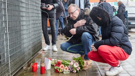 Ein Mann bekreuzigt sich am Gebäude der Zeugen Jehovas an der Deelböge im Hamburger Stadtteil Alsterdorf, nachdem Blumen und Kerzen niedergelegt wurden. 