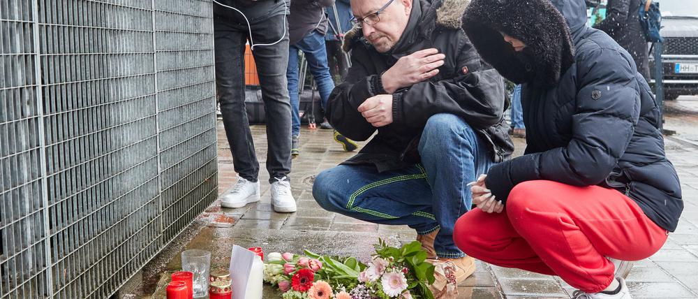 Ein Mann bekreuzigt sich am Gebäude der Zeugen Jehovas an der Deelböge im Hamburger Stadtteil Alsterdorf, nachdem Blumen und Kerzen niedergelegt wurden.