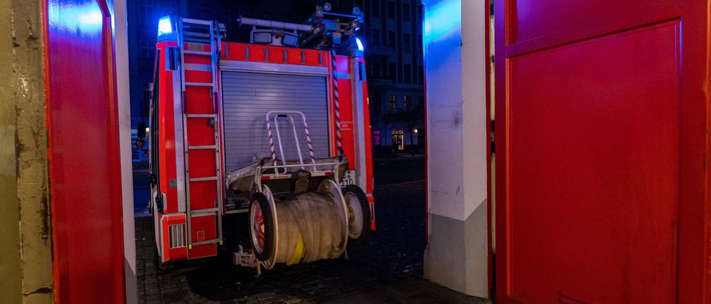 Ein Löschfahrzeug verlässt mit Blaulicht eine Feuerwache.