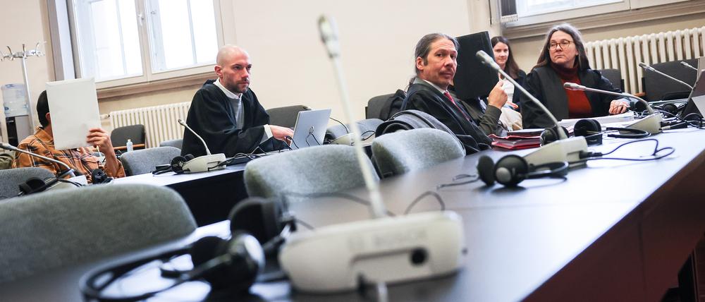 Die Angeklagten (l und 4.v.l) sitzen vor Beginn des Prozesstages neben sitzen neben ihren Anwälten und Anwältinnen im Gerichtssaal im Strafjustizgebäude und verbergen ihre Gesichter. Wegen des Schmuggels von mehr als zwei Tonnen Kokain müssen sich zwei Männer im Alter von 58 und 59 Jahren vor dem Landgericht Hamburg verantworten.