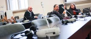 Die Angeklagten (l und 4.v.l) sitzen vor Beginn des Prozesstages neben sitzen neben ihren Anwälten und Anwältinnen im Gerichtssaal im Strafjustizgebäude und verbergen ihre Gesichter. Wegen des Schmuggels von mehr als zwei Tonnen Kokain müssen sich zwei Männer im Alter von 58 und 59 Jahren vor dem Landgericht Hamburg verantworten.