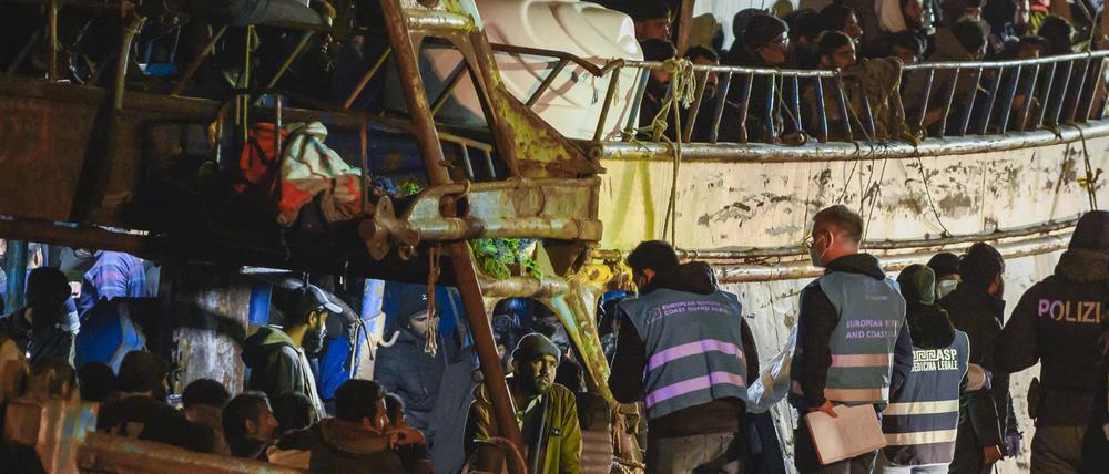 Die Polizei kontrolliert ein Fischerboot mit etwa 500 Migranten, das am frühen Morgen in den süditalienischen Hafen von Crotone einläuft.