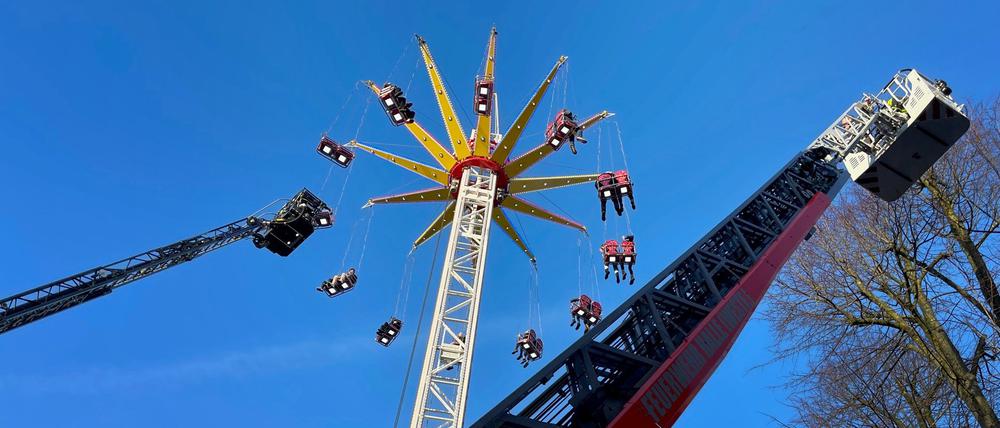 Menschen werden wegen eines Defekts in einem Kettenkarussell auf einer Kirmes in Halle (Westfalen) von der Feuerwehr mit Leiterwagen gerettet..