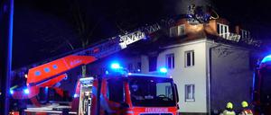 Einsatzkräfte der Feuerwehr löschen den Brand in einem Haus. In einem Haus in Berlin-Nikolassee ist am Samstagabend ein Feuer ausgebrochen.