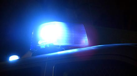 Blaulicht an einem Polizeiwagen leuchtet bei Nacht, Symbolbild.