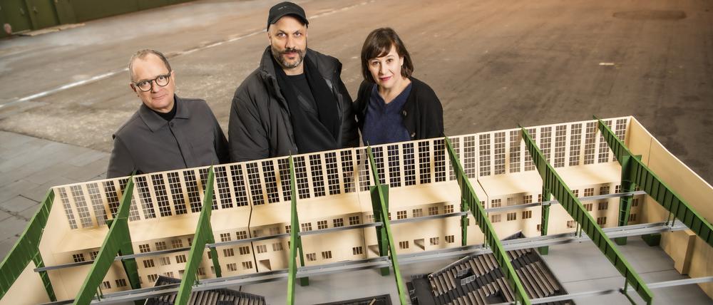 Susanne Moser und Philip Bröking, das Intendanzduo der Komischen Oper, sowie der Regisseur Tobias Kratzer (mit Kappe) vor dem Bühnenbild-Modell