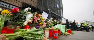 Blumen und Kerzen vor dem Eingangsbereich eines Gemeindehauses der Zeugen Jehovas.