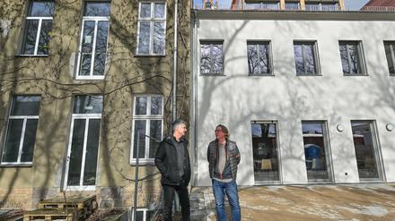 Axel Kalhorn (l), Chef des Trägervereins der Freien Schule Angermünde und Jan Teut, Unternehmer und Investor, stehen vor dem Schulgebäude.