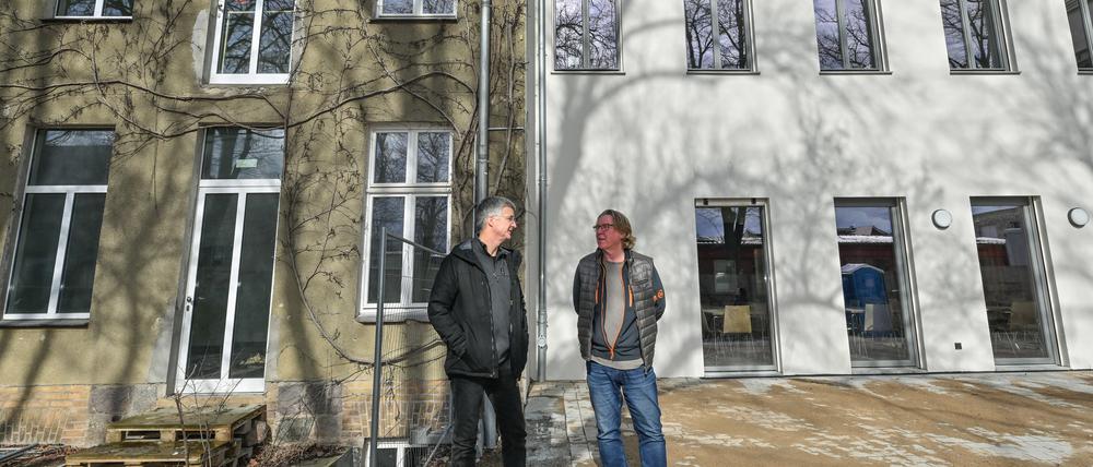 Axel Kalhorn (l), Chef des Trägervereins der Freien Schule Angermünde und Jan Teut, Unternehmer und Investor, stehen vor dem Schulgebäude.