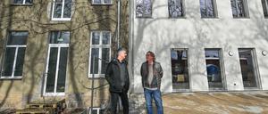 Axel Kalhorn (l), Chef des Trägervereins der Freien Schule Angermünde und Jan Teut, Unternehmer und Investor, stehen vor dem Schulgebäude. 