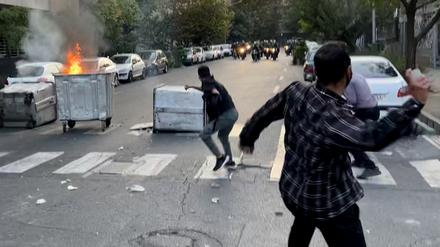 Ein Mülleimer brennt in der Mitte einer Kreuzung während einer Demonstration für Mahsa Amini (Symbolbild).