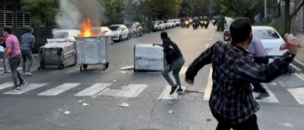 Ein Mülleimer brennt in der Mitte einer Kreuzung während einer Demonstration für Mahsa Amini (Symbolbild).