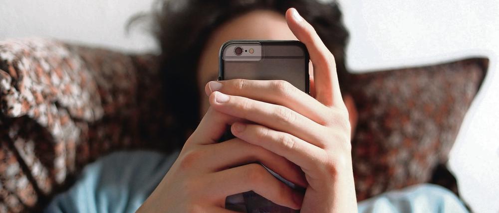 Ein 17-Jähriger benutzt am 01.04.2015 in Würzburg das iPhone 6. Foto: Karl-Josef Hildenbrand /dpa (zu 5. Berliner Mediensucht-Konferenz vom 13.11.2015) +++(c) dpa - Bildfunk+++