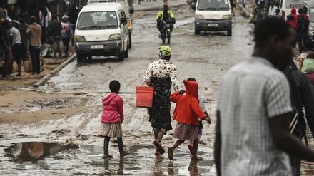 Malawi, Blantyre: Menschen gehen eine mit Wasser überschwemmte Straße entlang, nachdem der tropische Zyklon Freddy schwere Regenfälle verursacht hat.