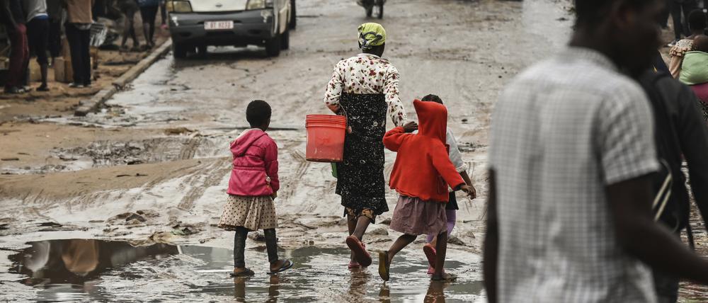 Malawi, Blantyre: Menschen gehen eine mit Wasser überschwemmte Straße entlang, nachdem der tropische Zyklon Freddy schwere Regenfälle verursacht hat.