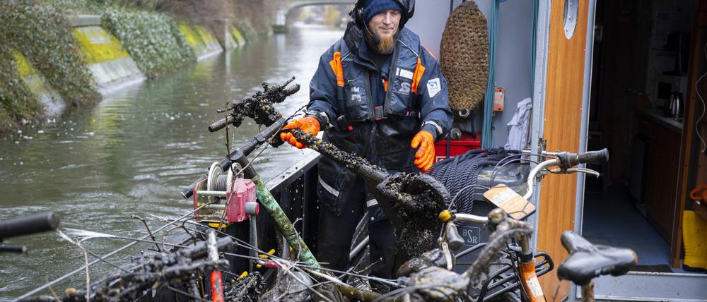 Stephan Strauch, Mitarbeiter vom Wasser- und Schifffahrtsamt, zieht bei einer Schiffsfahrt zur Hindernisbergung im Landwehrkanal einen E-Roller aus dem Wasser.