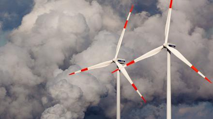 Windräder drehen sich vor den Kühltürmen des Braunkohlekraftwerks der Vattenfall Europe AG im brandenburgischen Jänschwalde.