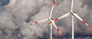Windräder drehen sich vor den Kühltürmen des Braunkohlekraftwerks der Vattenfall Europe AG im brandenburgischen Jänschwalde.