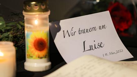 Ein Kondolenzbuch für die getötete Luise liegt neben Blumen und Kerzen in einer Kirche in Freudenberg aus. 