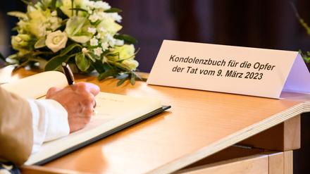 Eine Frau schreibt in das Kondolenzbuch für die Opfer der Amoktat bei den Zeugen Jehovas. 