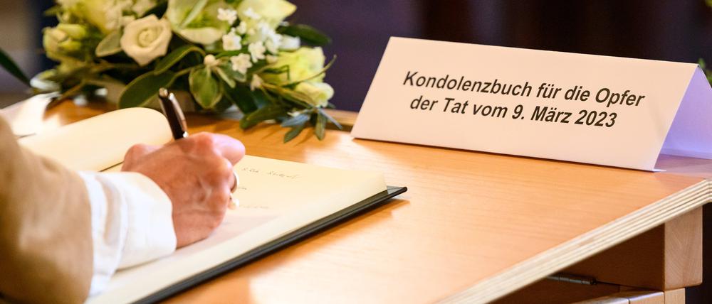 Eine Frau schreibt in das Kondolenzbuch für die Opfer der Amoktat bei den Zeugen Jehovas. 