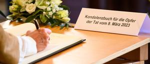 Eine Frau schreibt in das Kondolenzbuch für die Opfer der Amoktat bei den Zeugen Jehovas.