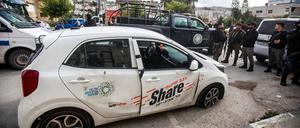 Palästinensische Sicherheitskräfte inspizieren ein von Israelis zerstörtes Auto, das von palästinensischen Jugendlichen mit Steinen beworfen wurde.