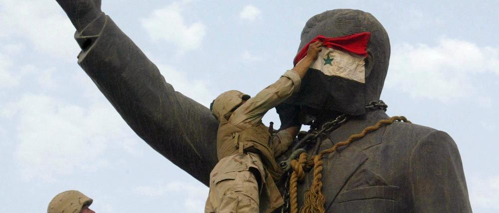 US-Soldaten bedecken eine Statue von Saddam Hussein mit einer irakischen Flagge (Archivbild vom April 2003).