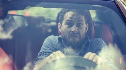 Stressed scared young man driver. Inexperienced anxious motorist concept