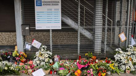 Blumen und Kerzen sind vor dem Eingangsbereich des Gemeindehauses der Zeugen Jehovas zu sehen. 