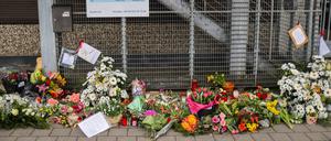 Blumen und Kerzen sind vor dem Eingangsbereich eines Gemeindehauses der Zeugen Jehovas zu sehen.