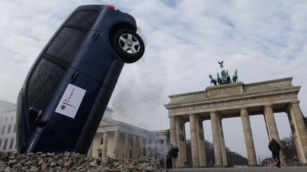 A SUV is piled into the ground in front of Berlin's landmark Brandenburg Gate during a protest "stop crashing the climate" by Greenpeace in Berlin, Germany, March 22, 2023. REUTERS/Michele Tantussi TPX IMAGES OF THE DAY