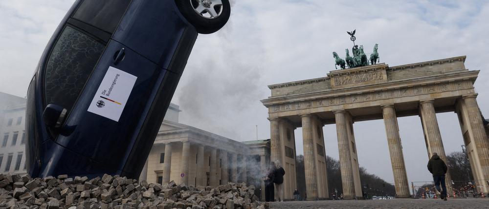 A SUV is piled into the ground in front of Berlin's landmark Brandenburg Gate during a protest "stop crashing the climate" by Greenpeace in Berlin, Germany, March 22, 2023. REUTERS/Michele Tantussi     TPX IMAGES OF THE DAY     