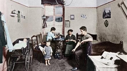 „Man kann einen Menschen mit einer Wohnung erschlagen wie mit einer Axt.“ Damit meinte Heinrich Zille wohl Wohnungen wie diese in der Kreuzberger Ritterstraße 124, fotografiert 1913, später digital koloriert: Quergebäude, Parterre. Stube ohne Heizung,  zugleich Arbeitsraum für Konfektion.