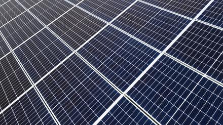 Solaranlagen sind für ein Photovoltaik-Speicher-Kraftwerk auf einer Wiese montiert. 