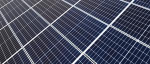 Solaranlagen sind für ein Photovoltaik-Speicher-Kraftwerk auf einer Wiese montiert. 