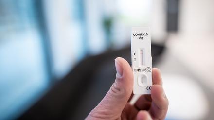 Ein Mann hält einen Corona-Schnelltest in der Hand., Symbolbild.