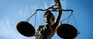 Eine Statue der Justitia hält eine Waage in der Hand.