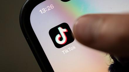 Ein Teenager tippt auf das Icon TikTok-App auf einem Smartphone. (Symbolbild).