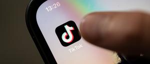 Ein Teenager tippt auf das Icon TikTok-App auf einem Smartphone. (Symbolbild).