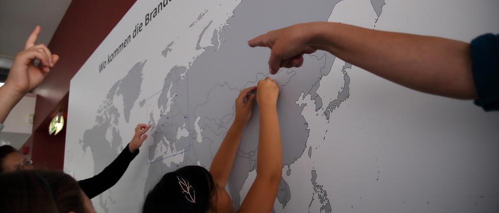 Schüler markieren auf einer Weltkarte ihre Herkunft - in der Ausstellung im Rahmen des außerschulischen Bildungsangebots „Ein Tag in Potsdam – Geschichte erleben - Auf den Spuren der Migranten“ (Symbolbild).