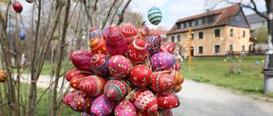 11.04.2019, Thüringen, Langenwetzendorf: Bunt bemalte Ostereier hängen an einem Strauch im Park.