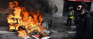  Ein Demonstrant geht während einer Kundgebung gegen das Gesetz zur Reform des Rentensystems in Rennes an brennenden Trümmern vorbei.