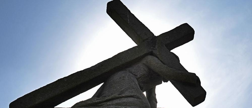 Eine Jesus-Statue unter dem Kreuz.