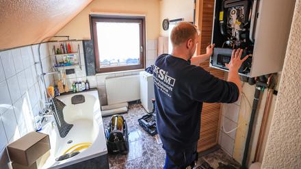 ARCHIV - 01.03.2023, Sachsen, Markranstädt: Ein Mitarbeiter einer Sanitär- und Heizungsbaufirma installiert eine moderne Gasbrennwerttherme in einem Einfamilienhaus. (zu dpa «Söder: Pläne für Heizungstausch sind gegen Eigentümer gerichtet») Foto: Jan Woitas/dpa +++ dpa-Bildfunk +++
