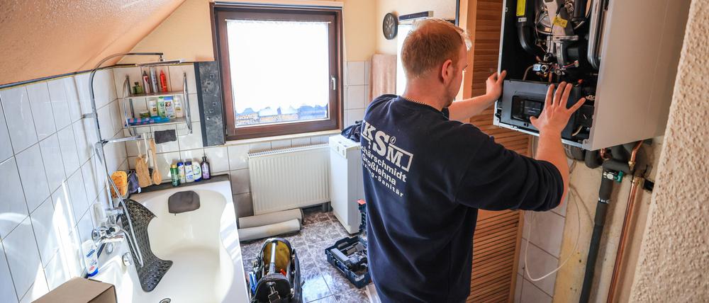 ARCHIV - 01.03.2023, Sachsen, Markranstädt: Ein Mitarbeiter einer Sanitär- und Heizungsbaufirma installiert eine moderne Gasbrennwerttherme in einem Einfamilienhaus. (zu dpa «Söder: Pläne für Heizungstausch sind gegen Eigentümer gerichtet») Foto: Jan Woitas/dpa +++ dpa-Bildfunk +++